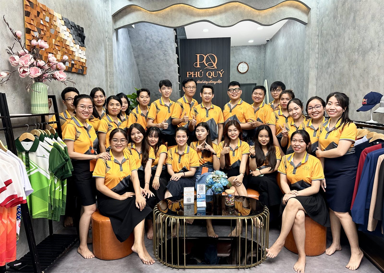 Tập thể nhân viên Đồng Phục Phú Quý mặc đồng phục công ty áo polo tại showroom