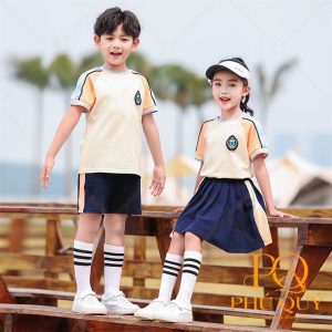 Hai bé mặc đồng phục mầm non áo thun cổ tròn và váy