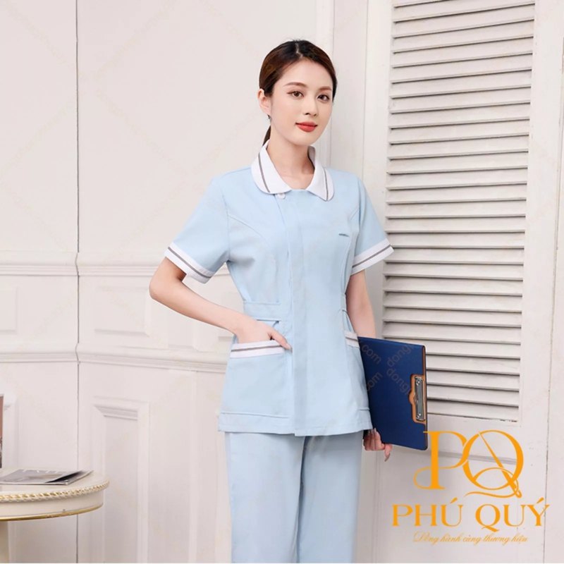 Điều dưỡng nữ mặc áo xanh nhạt tay ngắn cầm bìa hồ sơ