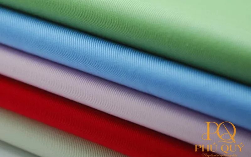 Các cây vải nhiều màu xếp chồng dùng may áo